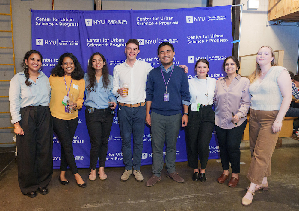 group of 8 diverse students smiling in front of CUSP step and repeat