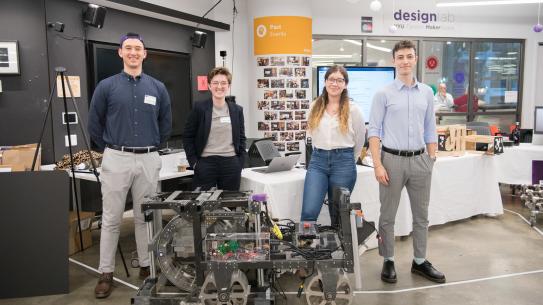 4 team members standing behind robot