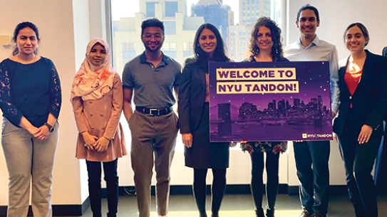 diverse group of young academics with faculty holding welcome sign