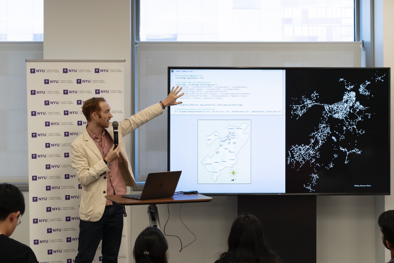 A faculty fellow pointing onto a screen displaying a map of Boston