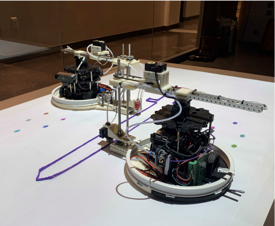 Small robot performing 3D printing on a flat surface.