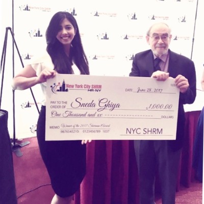 Alum Sneha Ghiya holding a large award check with Prof Kaufman